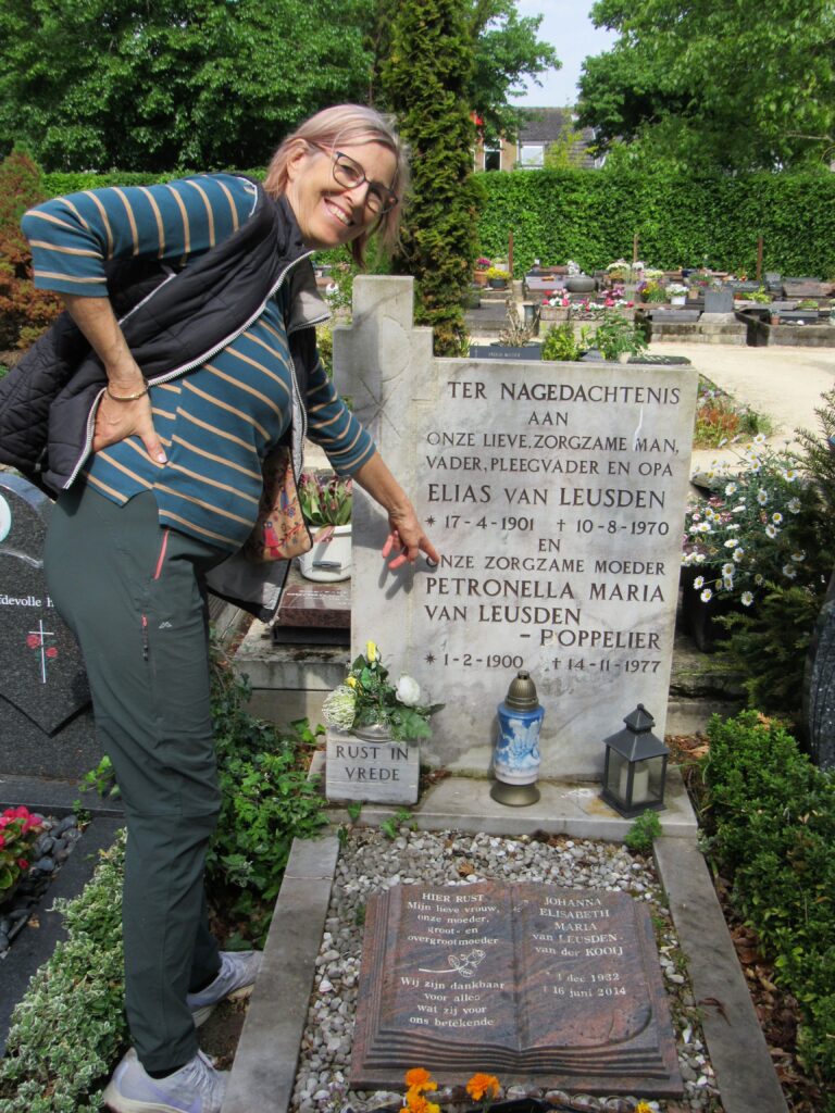 woman pointing at headstone in graveyard