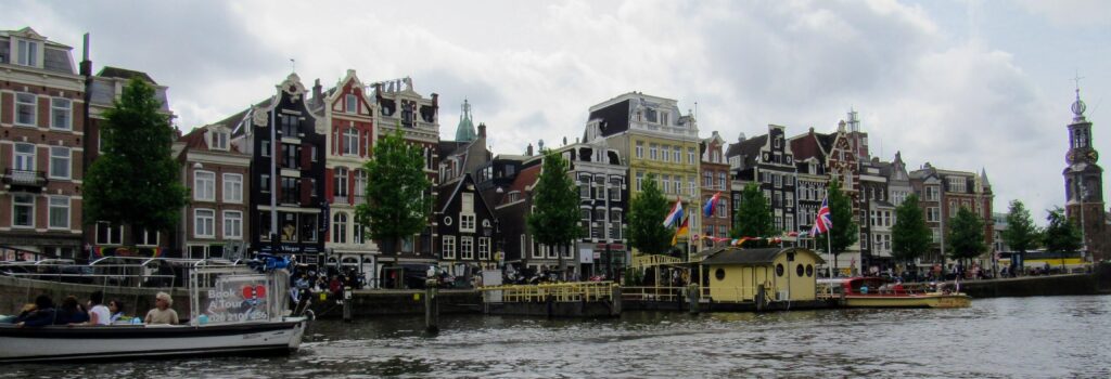 view along the canal in Amsterdam showing houses and boats