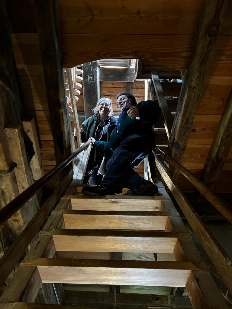 People standing at the stop of very narrow staircase