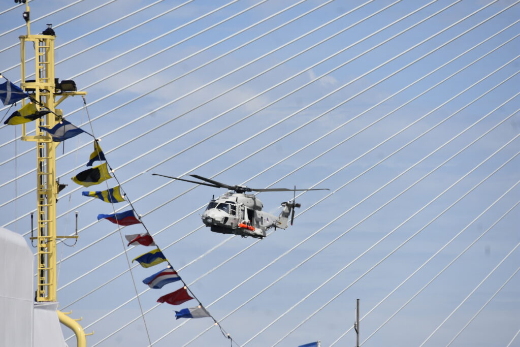 Helicopter with bridge wires in background