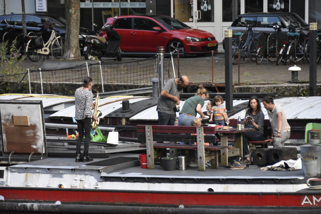 Man playing saxaphone on a barge